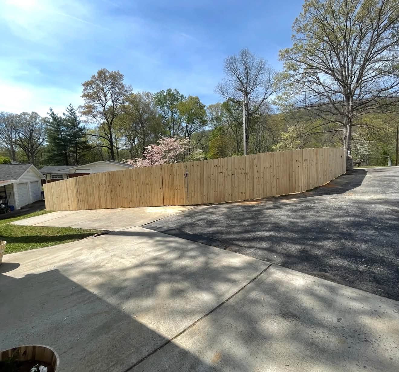 Wood privacy fence with gate at a driveway entrance, built by Tennessee Fence Systems LLC